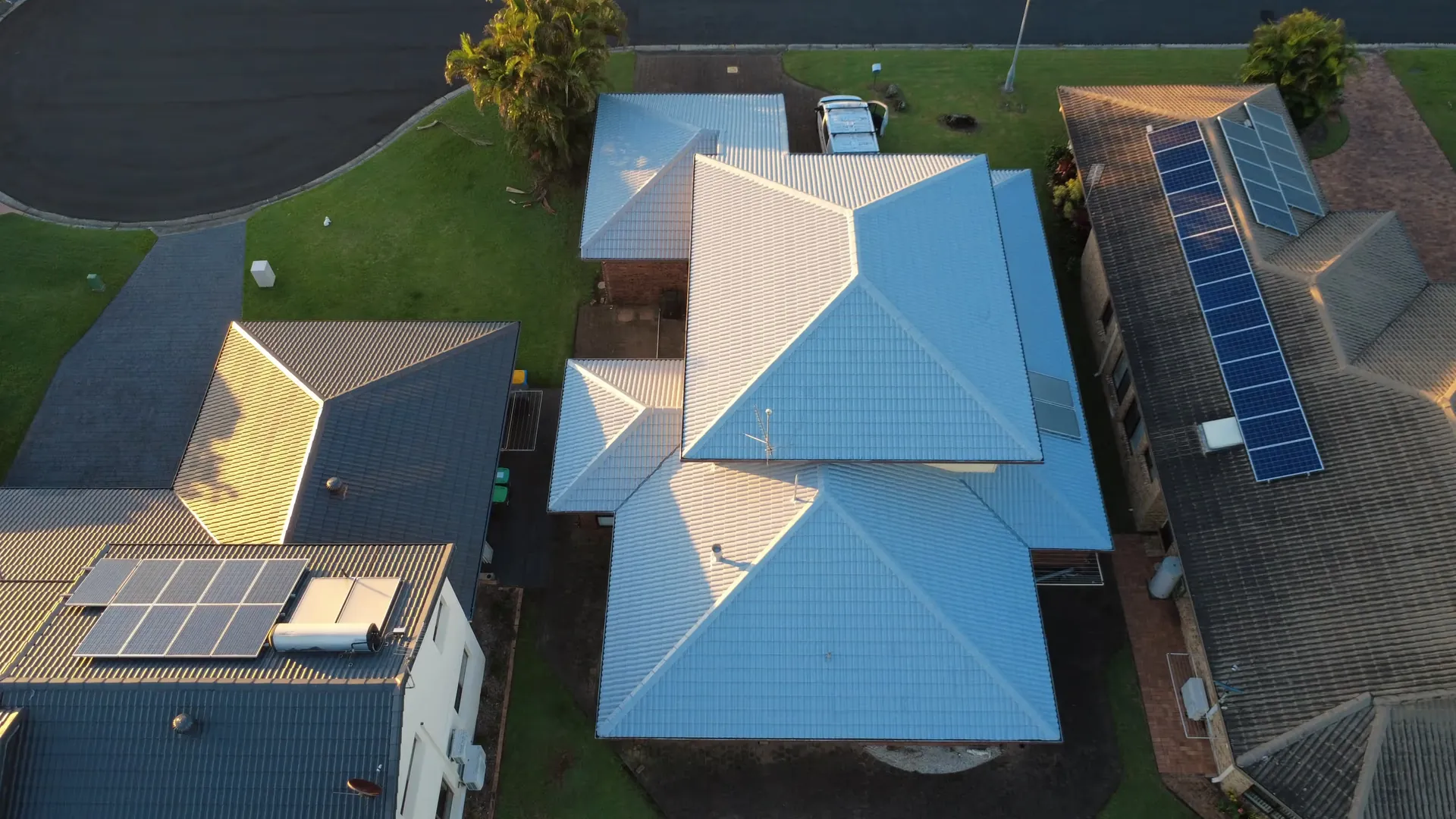 Aerial view of a freshly restored tiled roof and guttering on a Lismore home at golden hour