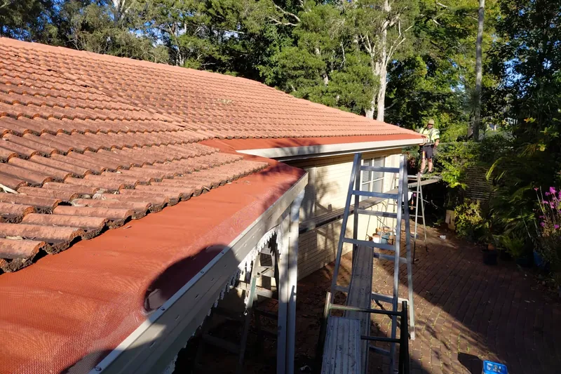 Gutter guard mesh fitted along the edge of a terracotta tiled roof